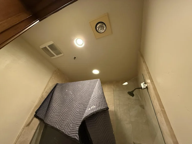 Bathroom remodel in progress with the tiled shower protected during work