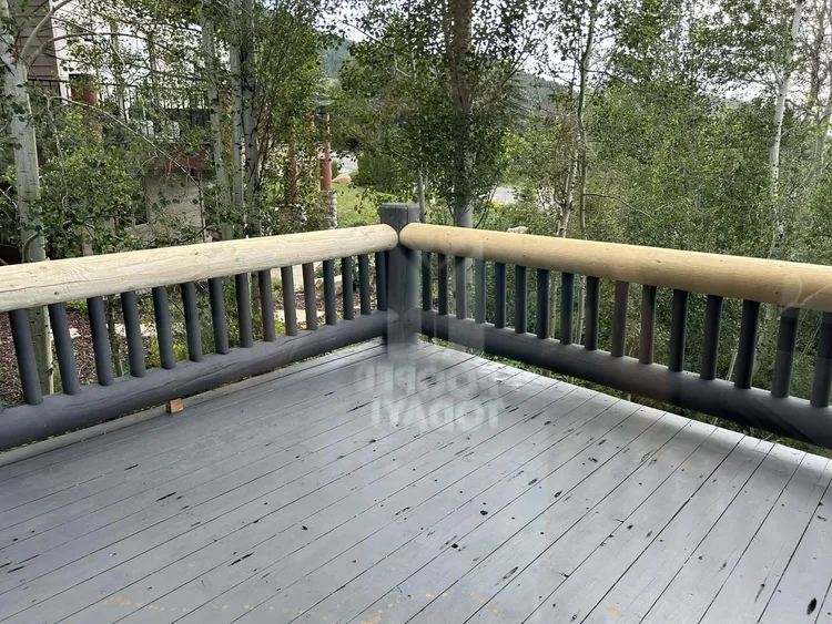Refinished deck with repainted railing and mountain aspens beyond