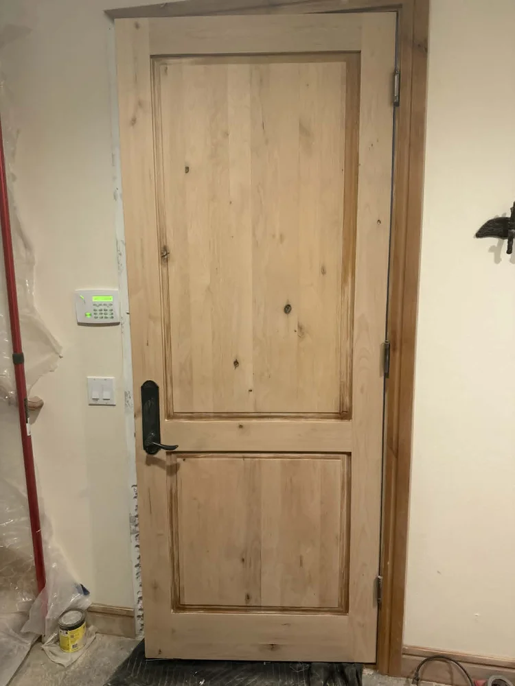 Newly installed knotty alder door and casing before finishing